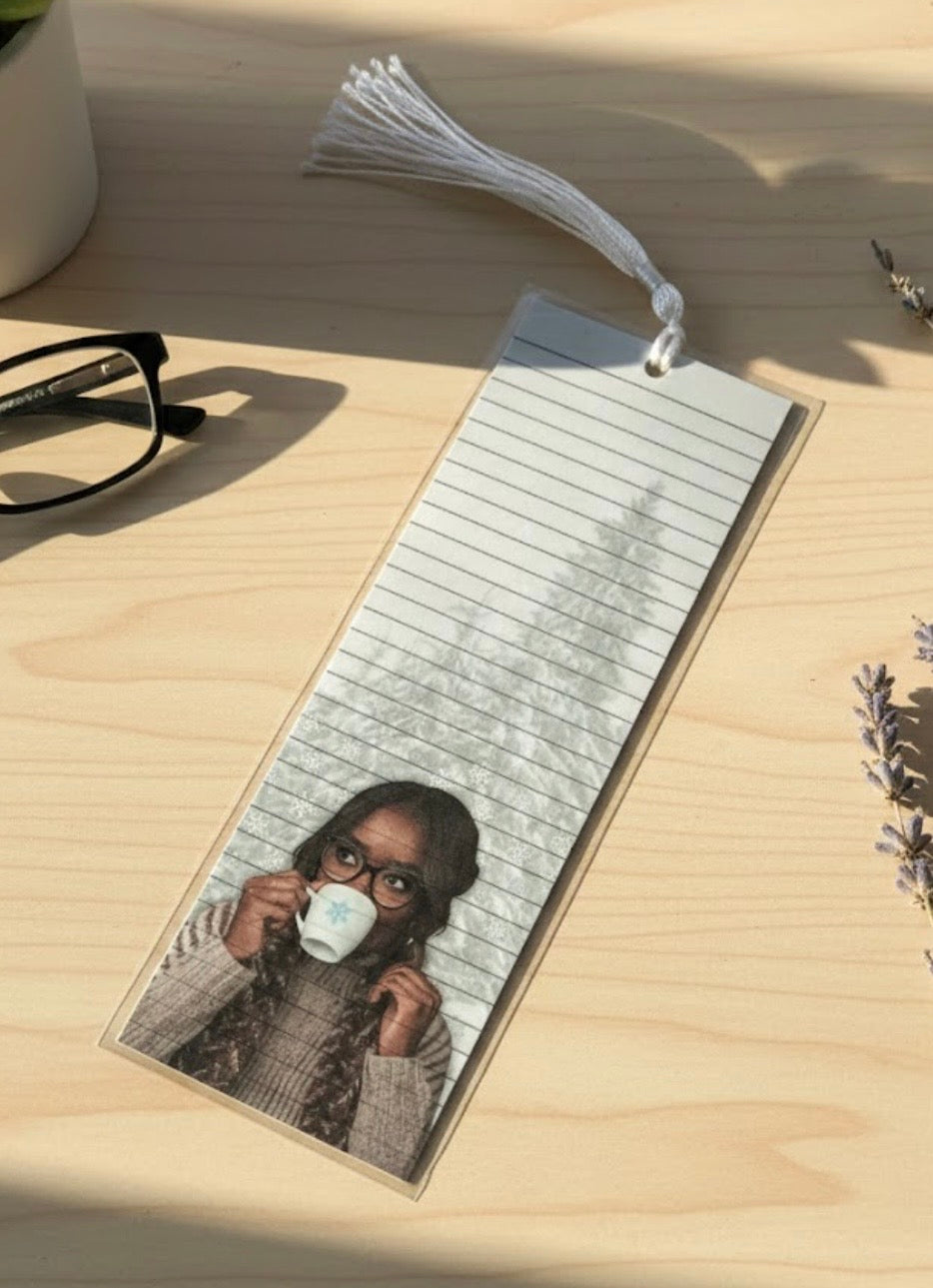 Bookmark with a photo of a person wearing glasses and a mask on a wooden surface.