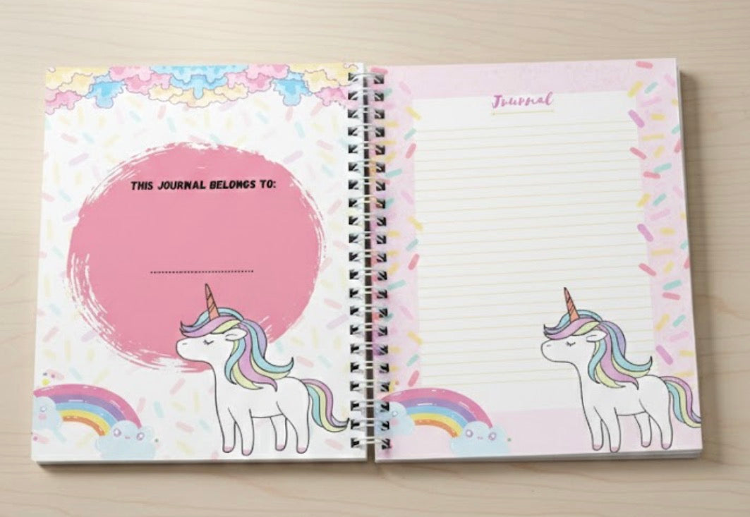 Journal with unicorn and rainbow design on a wooden surface