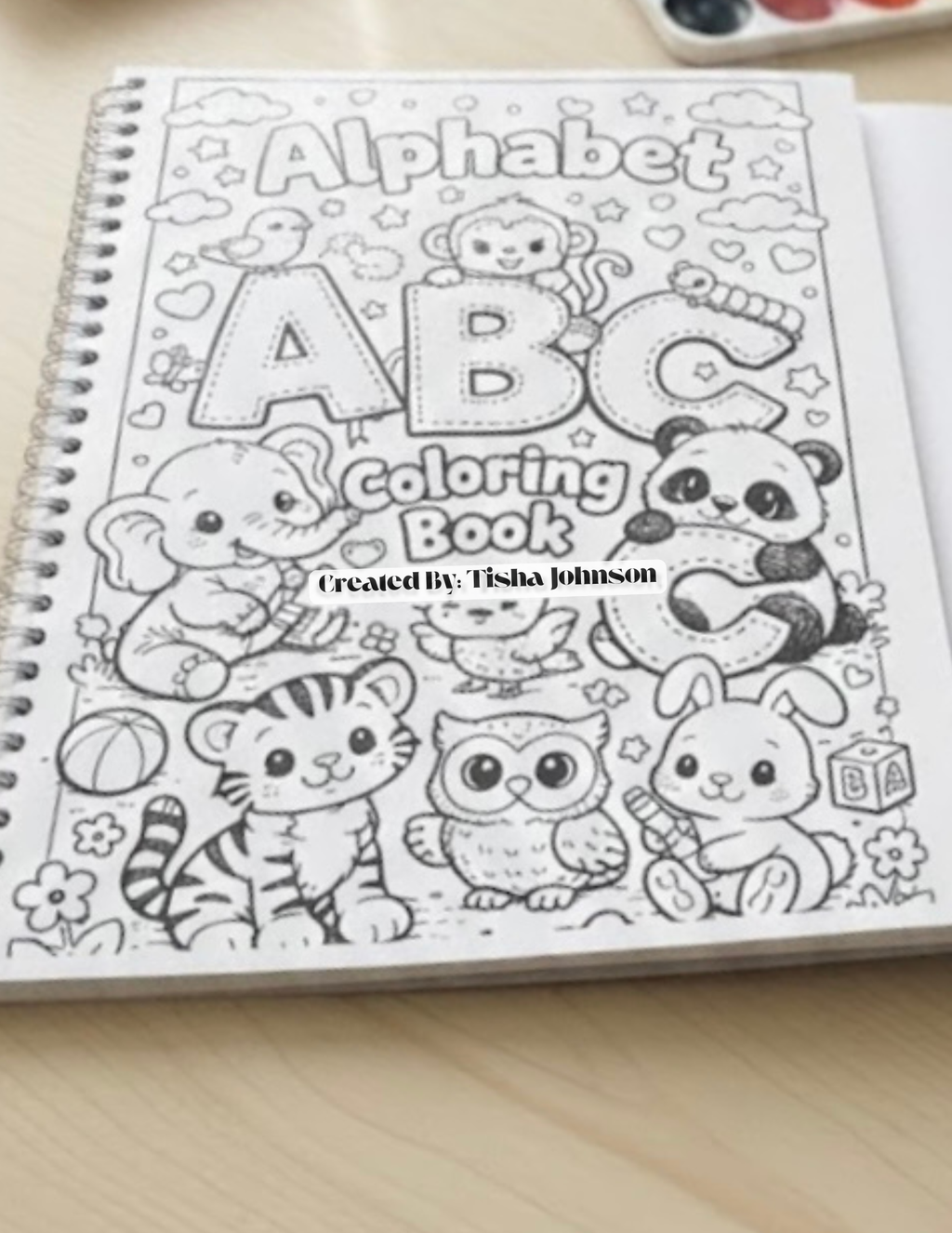 Coloring book with alphabet and animals on a wooden surface