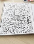 Coloring book with alphabet and animals on a wooden surface