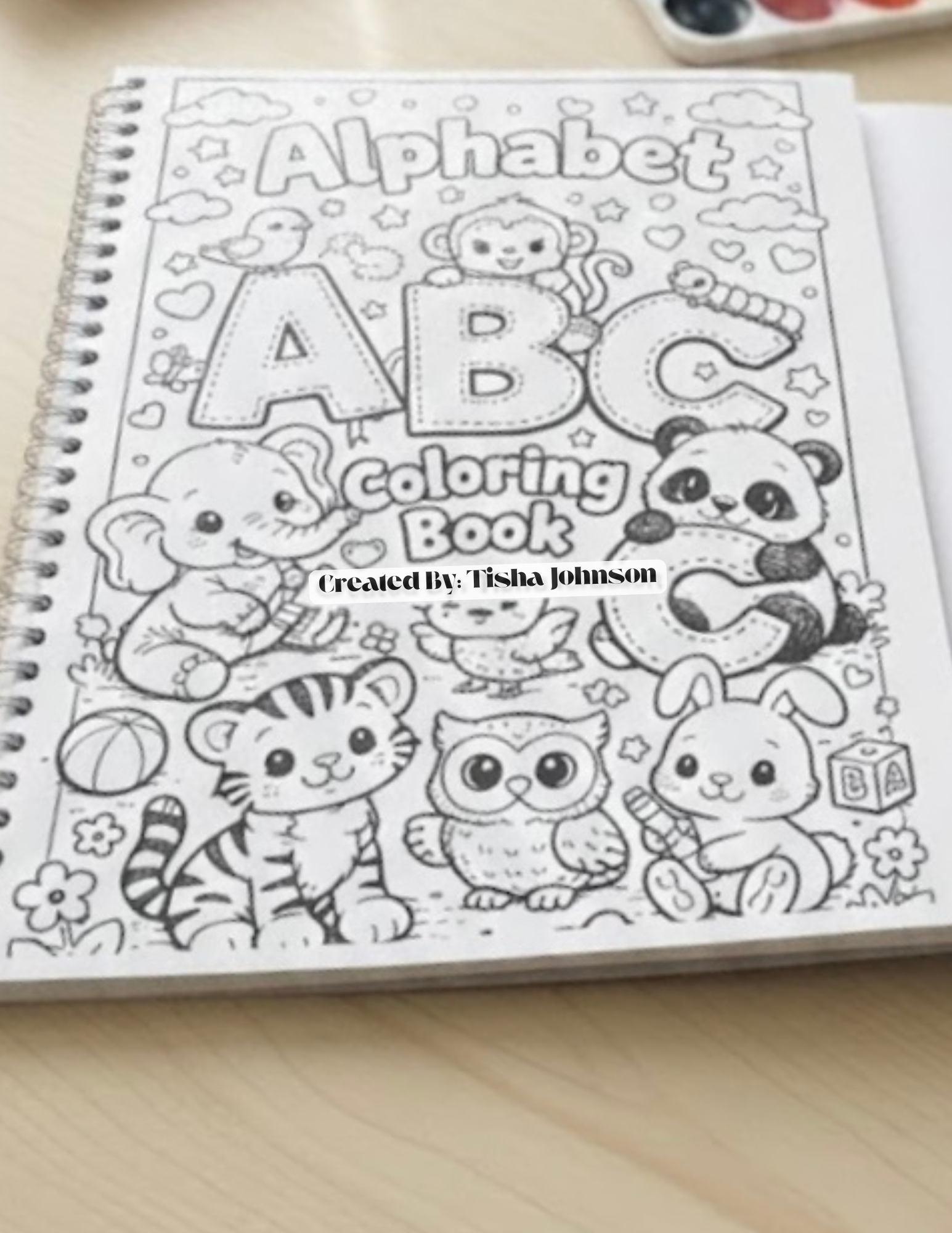 Coloring book with alphabet and animals on a wooden surface