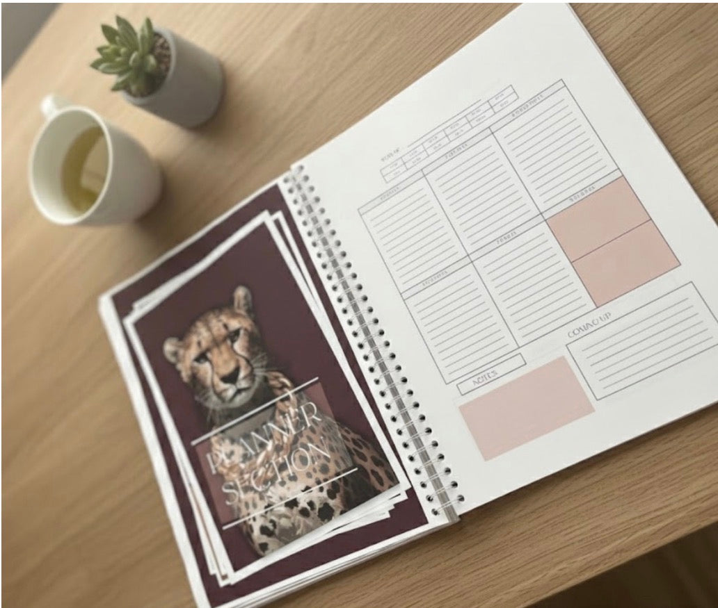 Open planner with a cheetah design on a wooden desk