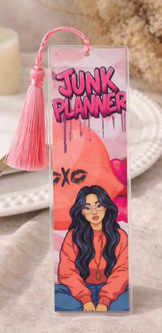 Bookmark with 'Junk Planner' text and a tassel on a textured surface