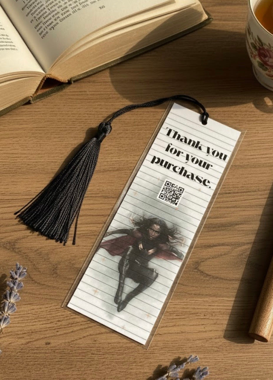 Bookmark with a design and text on a wooden surface with a book and tea cup.