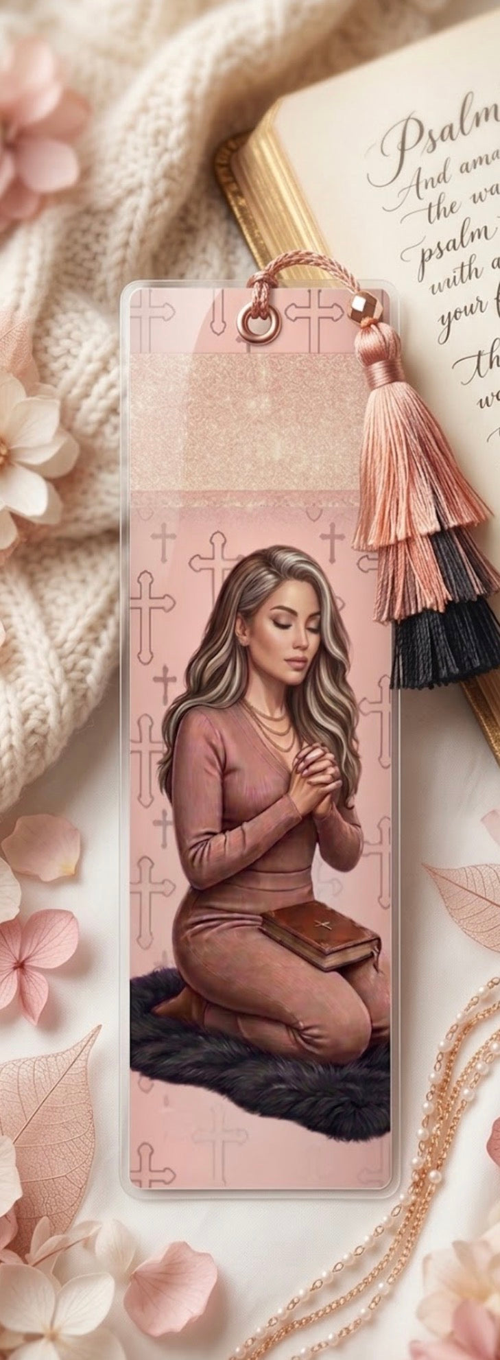 Decorative bookmark with a woman praying, surrounded by flowers and stationery items.