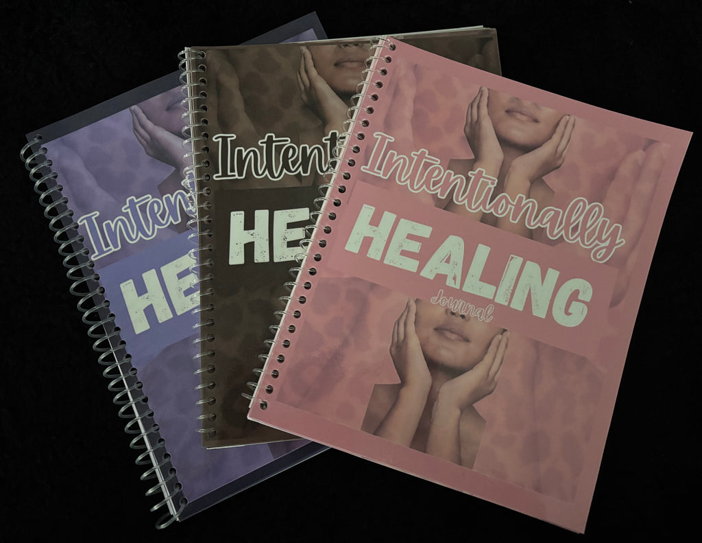 A photo of all three intentionally healing journals together. Colors pink, purple, and brown.