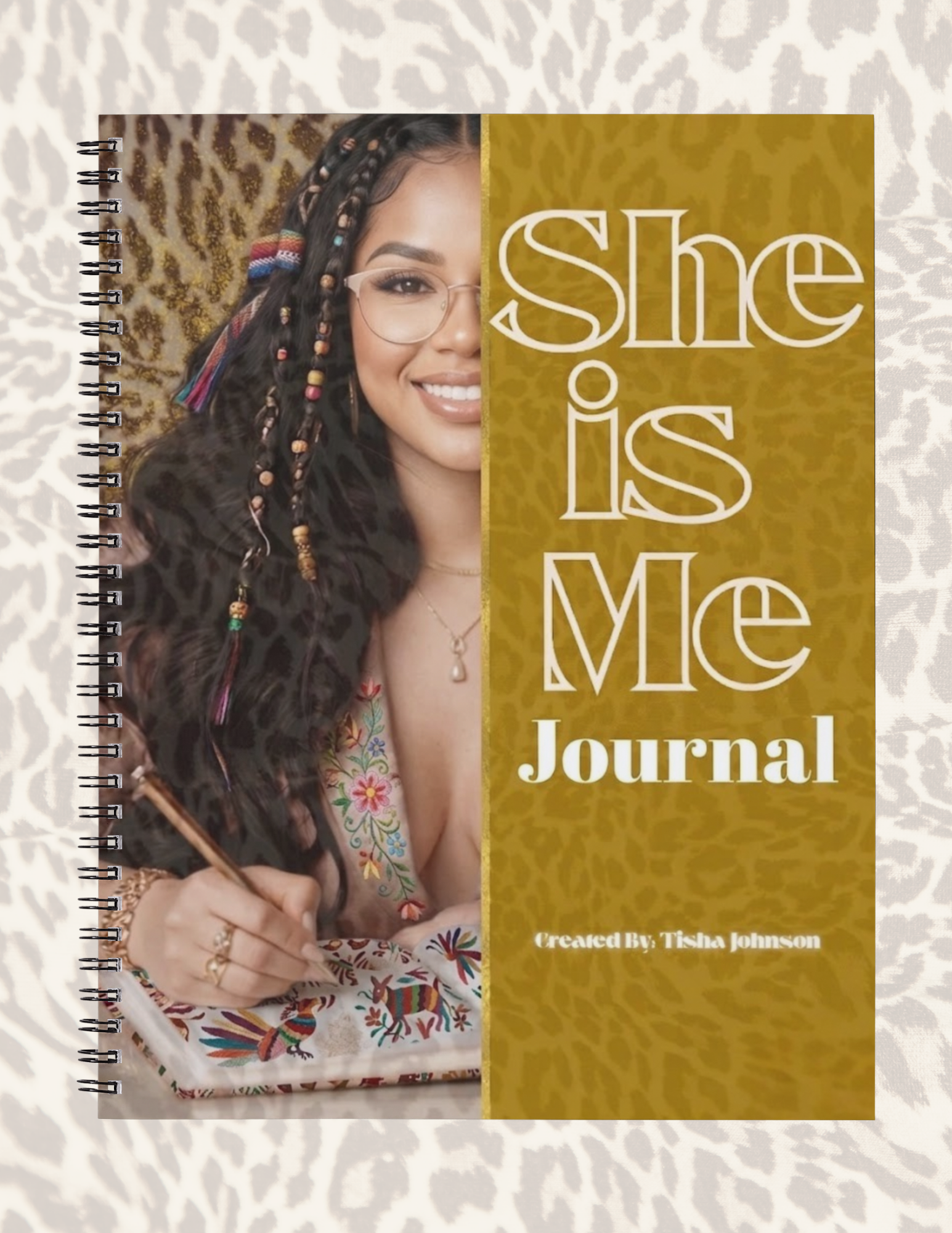 Journal titled 'She is Me' with a photo of a woman on the cover, placed on a textured surface.