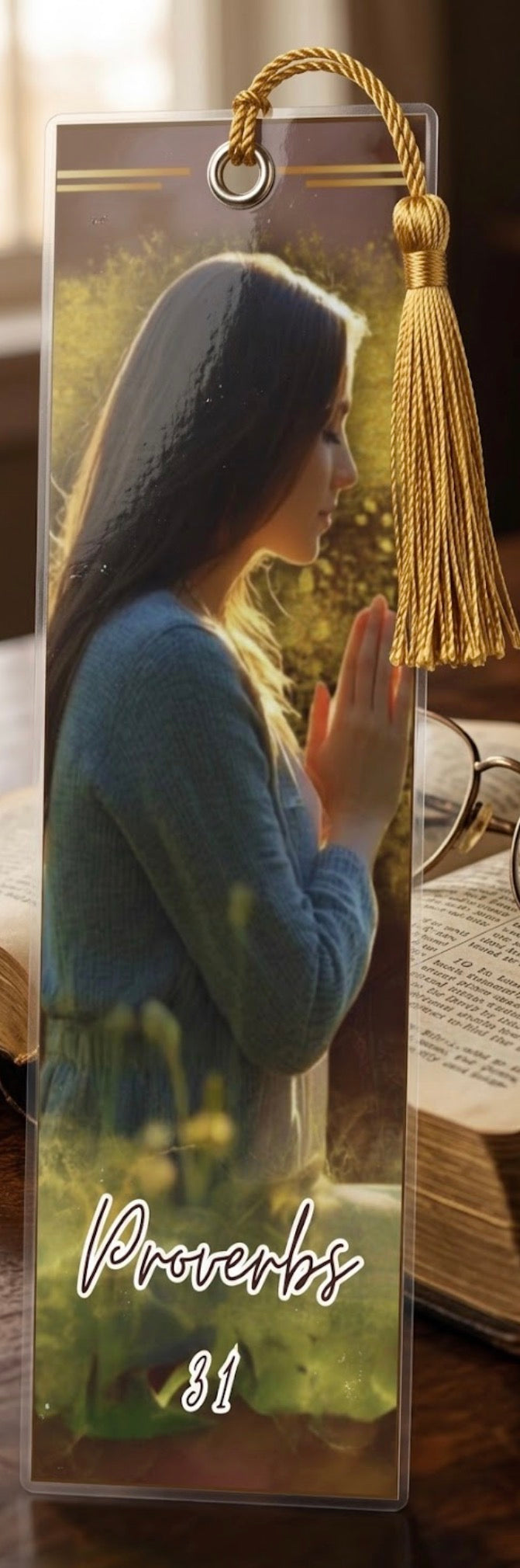 Bookmark with a woman praying, tassel, and 'Proverbs 31' text on an open book background.