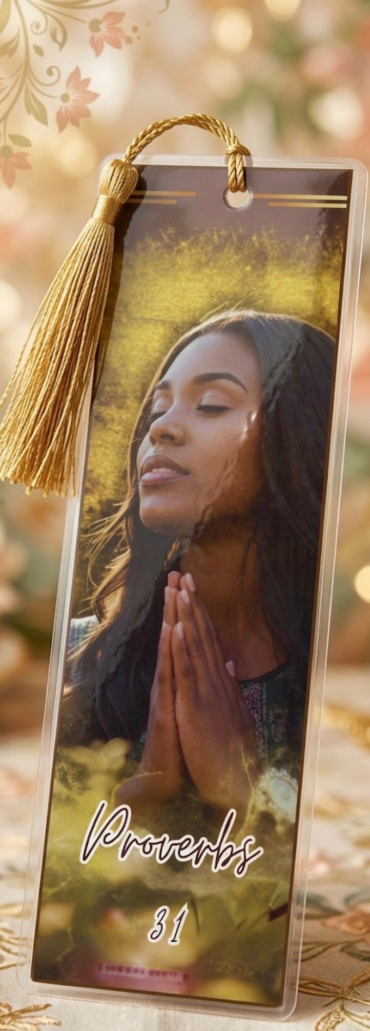 Bookmark with a woman praying and 'Proverbs 31' text, gold tassel on a blurred nature background
