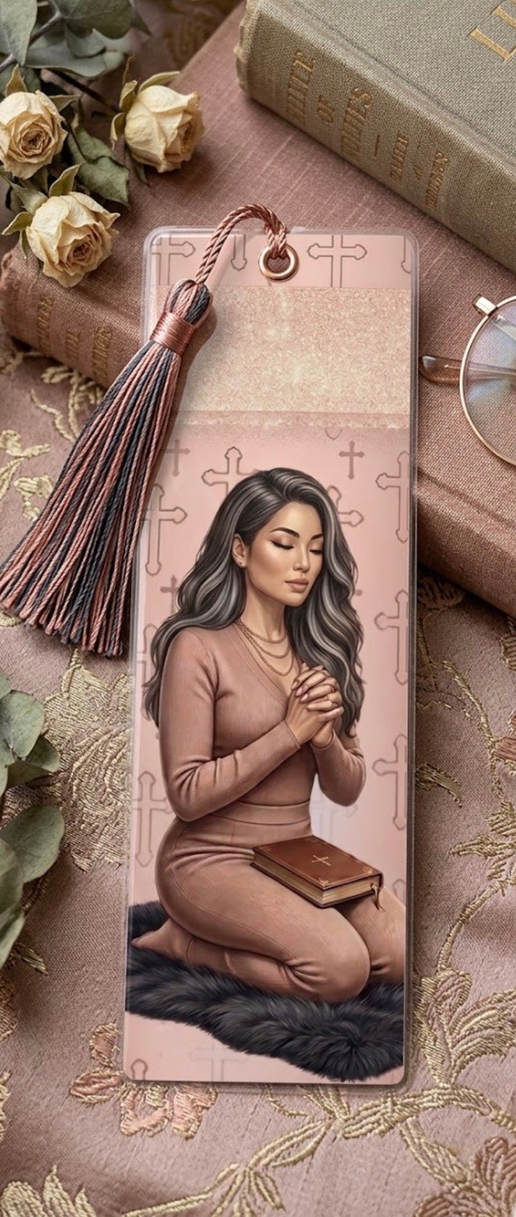 Bookmark with a design of a woman holding a book, surrounded by flowers and books.