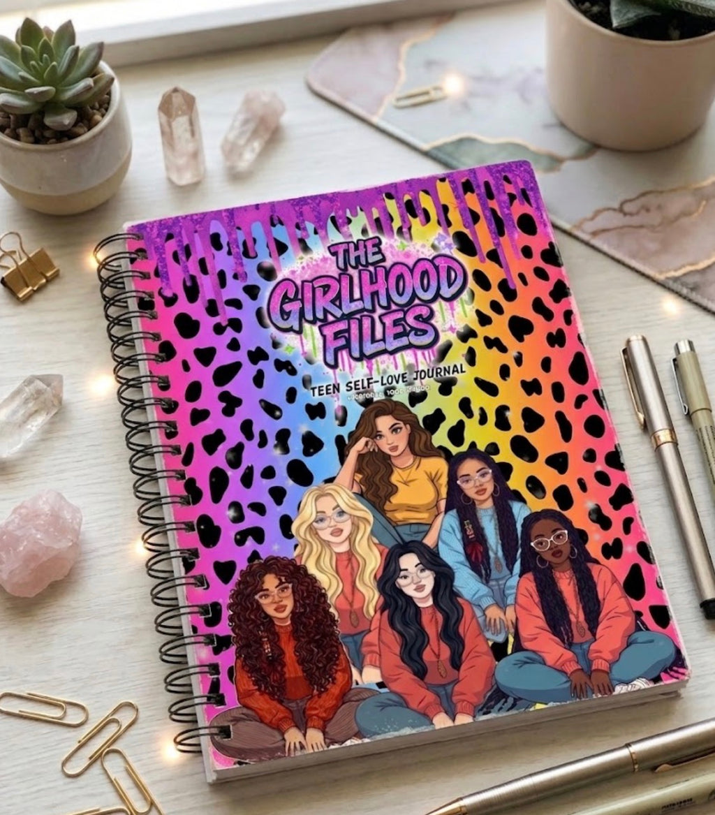 Notebook titled 'The Girlhood Files' on a desk with stationery items