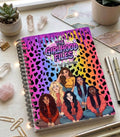 Notebook titled 'The Girlhood Files' on a desk with stationery items