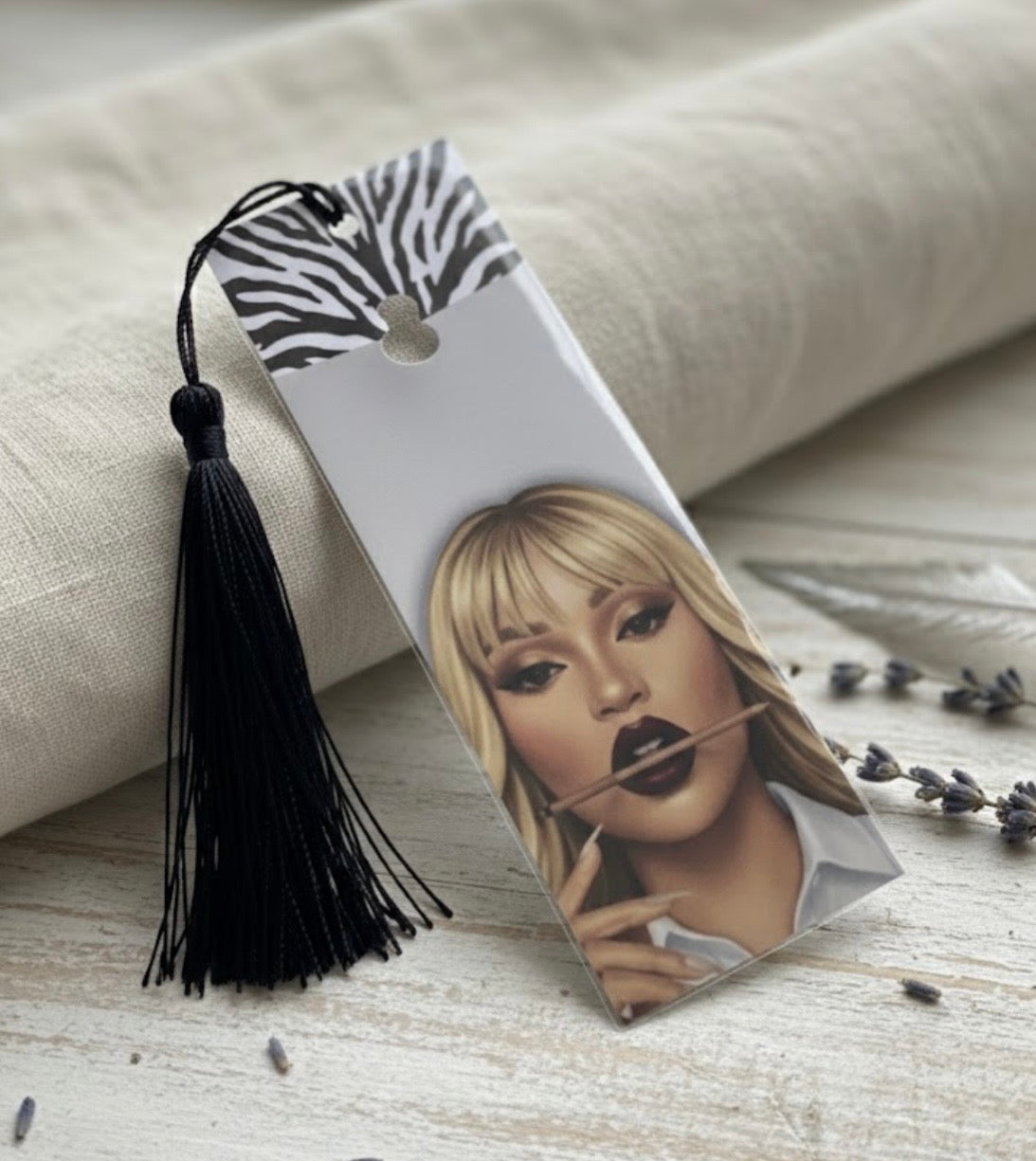 Bookmark with a portrait of a woman and a tassel on a textured surface
